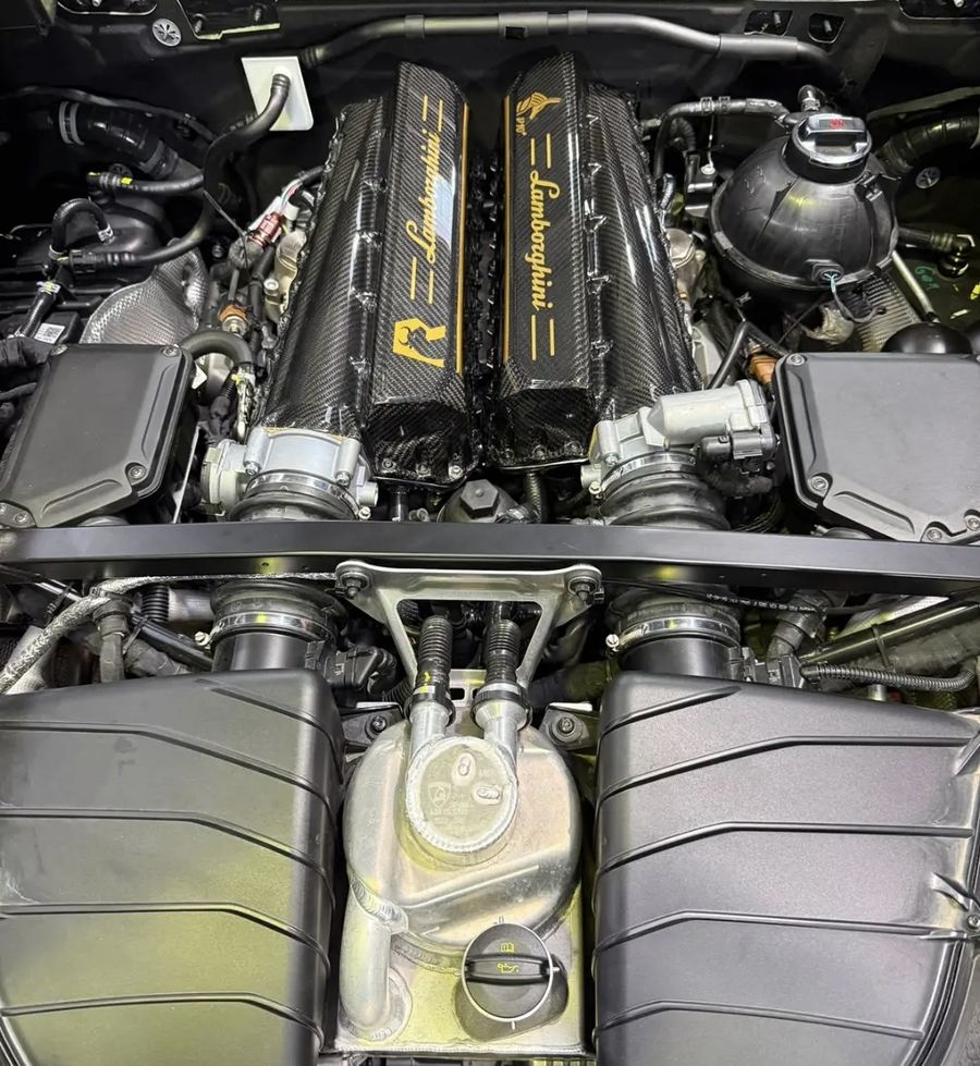 The Anubis Composite carbon intake manifold installed in a Lamborghini Huracán STO, between the factory cam covers.